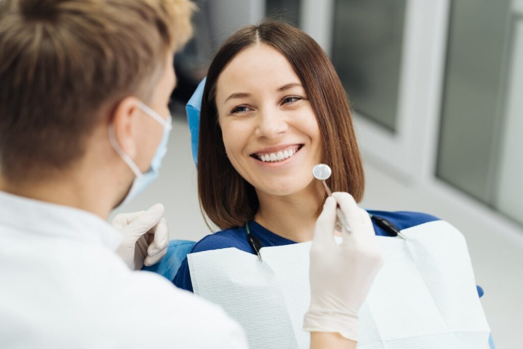 Dentistas profesionales mostrando los resultados de una transformación de sonrisa a su paciente explicando el costo y los tratamientos