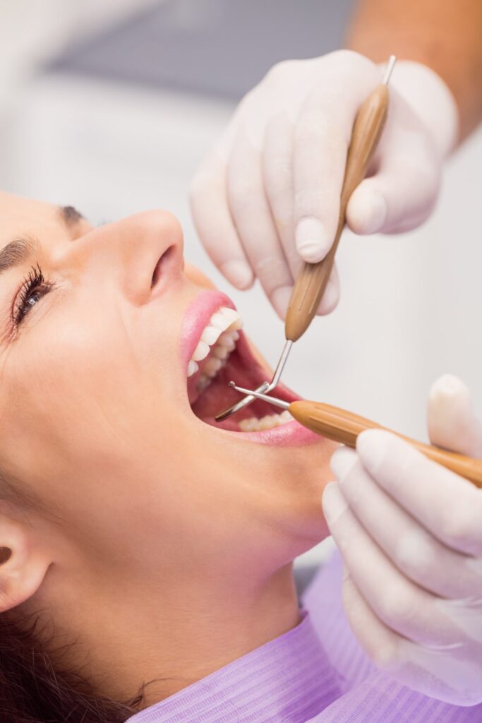 dentista haciendo un chequeo dental en un paciente femenino