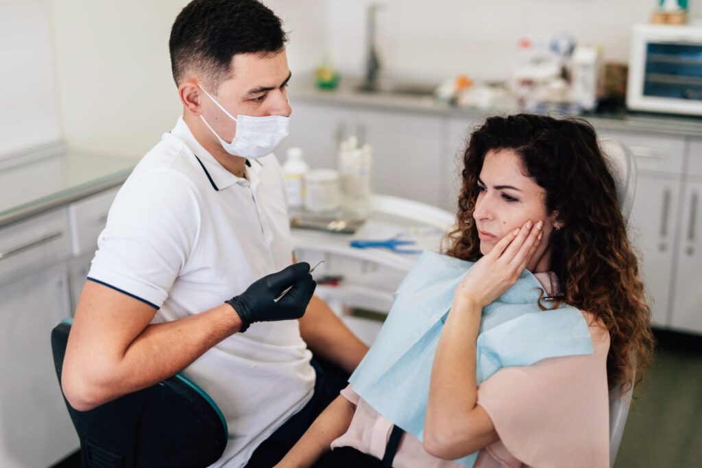 mujer con dolor de muelas dentista descubriendo cómo se siente el dolor de las muelas del juicio