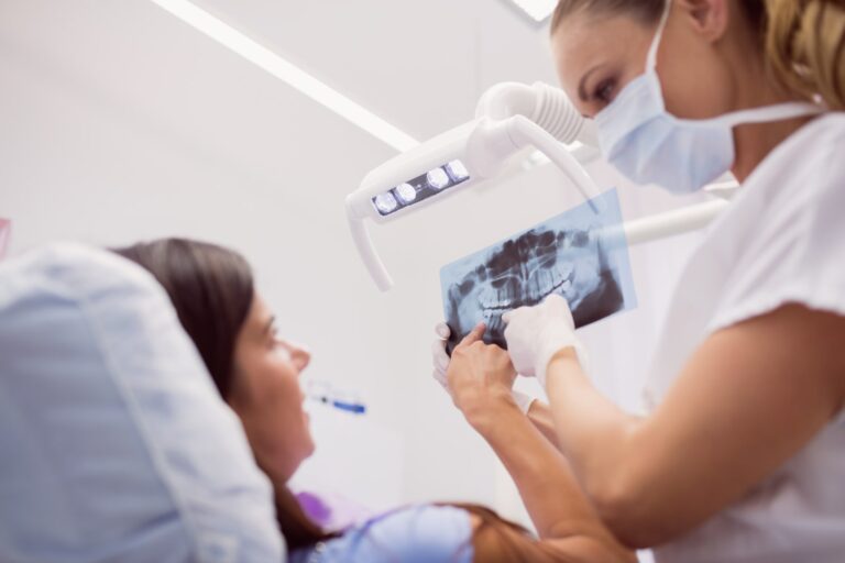dentista mostrando rayos x al paciente para explicar a qué edad le salen las muelas del juicio
