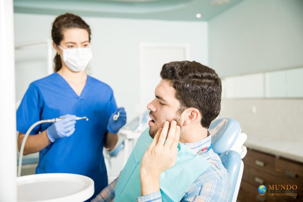 hombre-adulto-de-mediana-sufre-dolor-de-muelas-mientras-mira-al-dentista-con-herramientas-la-clínica-explica-el-costo-de-extracción-de-muelas del juicio