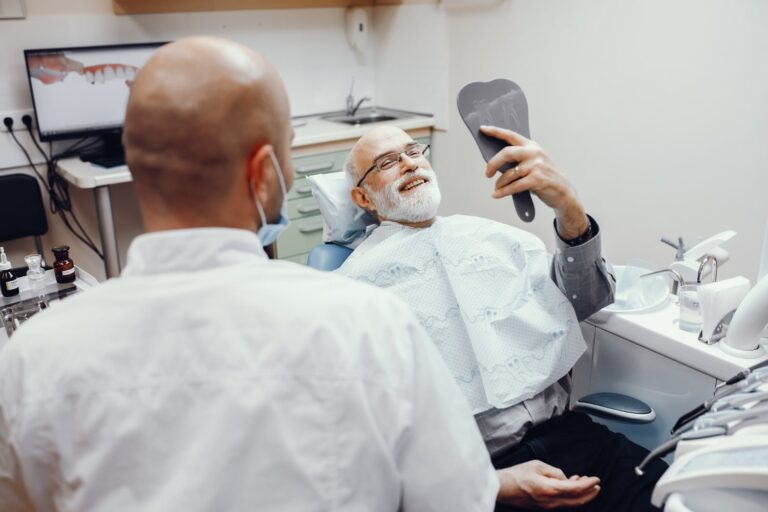 Anciano sentado en el consultorio del dentista sabiendo cuánto tiempo después de los implantes dentales puedo comer normalmente