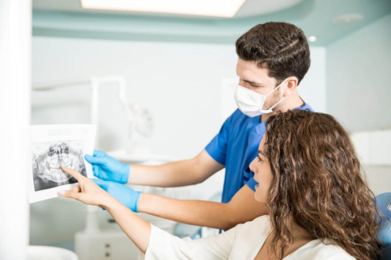 dentista adulto mostrando dientes de rayos x paciente femenino explicando dental implantes dentales costo carolina del sur